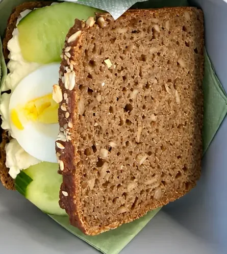 Vollkorn-Sandwich mit körnigem Frischkäse, Ei und Gurke